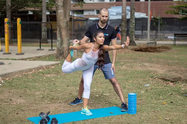 Personal trainer ohjaa asiakkaan tasapainoharjoitusta ulkona
