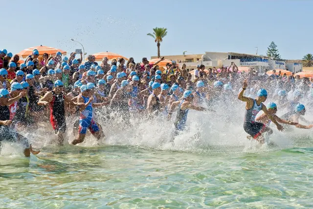 Triathlonistit juoksevat mereen uintiosuuden alkaessa