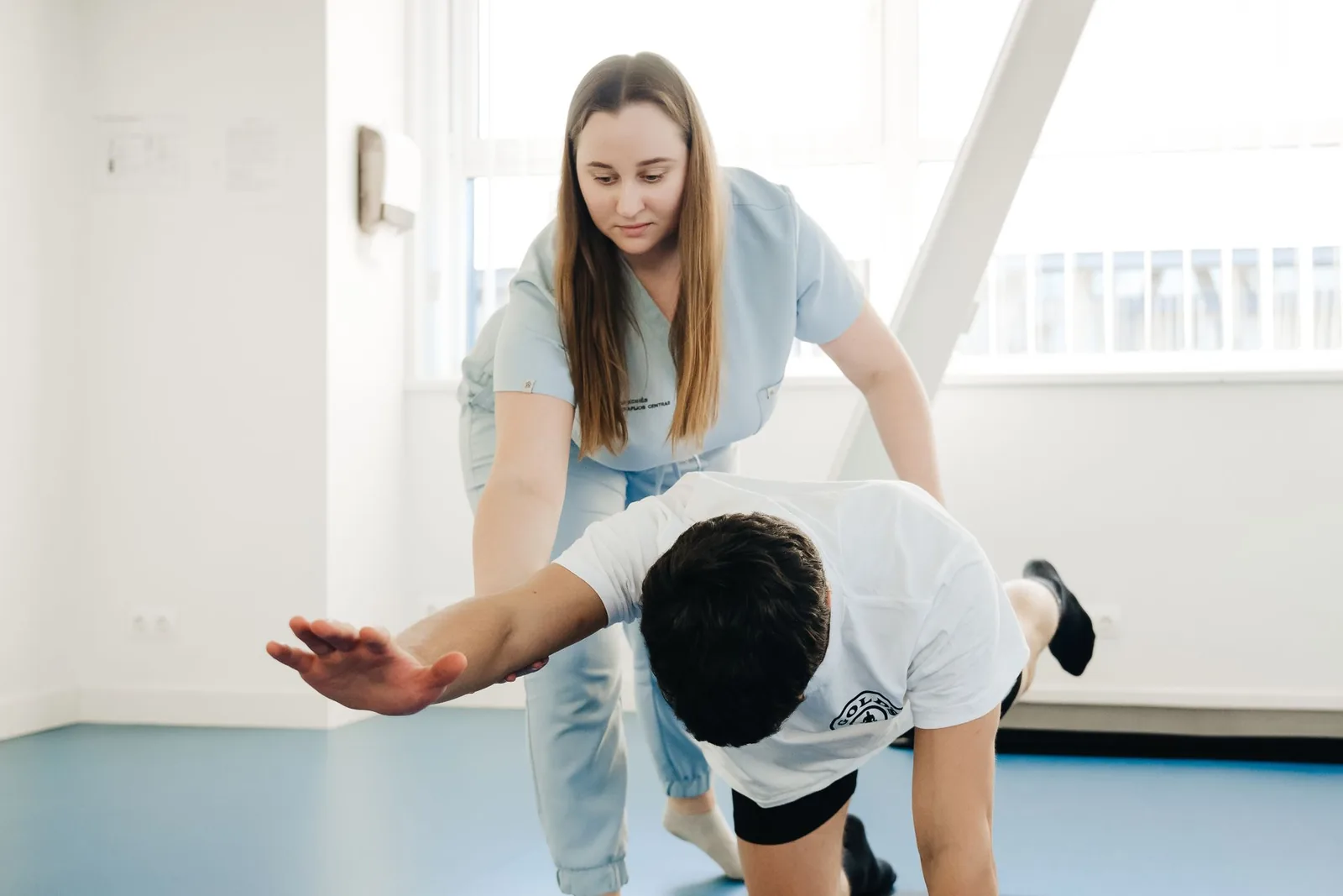 Fysioterapeutti ohjaa asiakasta liikeharjoituksessa